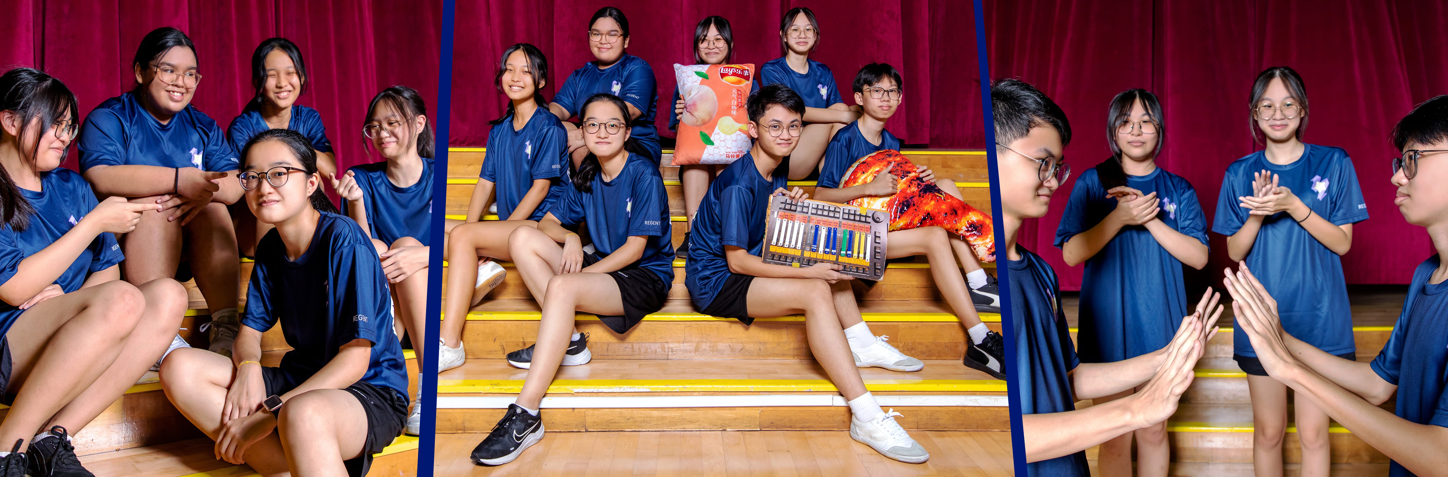 A group of students in matching blue shirts sit on wooden bleachers in front of red curtains, holding snacks and a mixing board.